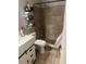 Bathroom featuring tiled shower, toilet, and modern sink with storage at 7206 Reindeer Rd, Tampa, FL 33619