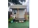 A backyard shed on artificial turf with a small porch and decorations at 7206 Reindeer Rd, Tampa, FL 33619