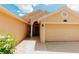 Close up of home's entrance featuring tiled walkway, covered entry, and attached two-car garage at 9852 Laurel Ledge Dr, Riverview, FL 33569