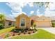 Charming single-story home featuring a 2-car garage and well-manicured landscaping on a sunny day at 9852 Laurel Ledge Dr, Riverview, FL 33569