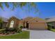 Charming single-story home featuring a 2-car garage and well-manicured landscaping on a sunny day at 9852 Laurel Ledge Dr, Riverview, FL 33569