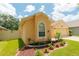 Well-maintained home exterior with manicured landscaping, flower beds, and lush green lawn at 9852 Laurel Ledge Dr, Riverview, FL 33569