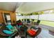 Bright enclosed lanai features wood-look flooring, cozy seating, and a lovely view of the backyard at 9852 Laurel Ledge Dr, Riverview, FL 33569