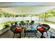 Enclosed lanai with comfortable seating, offering a tranquil view of the backyard and lush greenery at 9852 Laurel Ledge Dr, Riverview, FL 33569