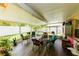 Enclosed lanai provides a relaxing space with wood-look flooring, seating, and views of the backyard at 9852 Laurel Ledge Dr, Riverview, FL 33569
