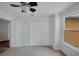A carpeted bedroom is brightly lit with a window and features a ceiling fan and closet at 1004 Black Knight Dr, Valrico, FL 33594