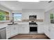 Modern kitchen with stainless steel appliances, white cabinetry, and stylish backsplash at 1004 Black Knight Dr, Valrico, FL 33594