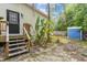 Side yard with a wooden deck, showing the exterior of the home and a blue storage unit at 10537 Fran St, New Port Richey, FL 34654