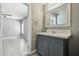 Bathroom featuring a gray vanity with white countertop and a decorative mirror at 10537 Fran St, New Port Richey, FL 34654