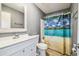Bathroom with white vanity, toilet, and shower featuring a beach-themed shower curtain at 10537 Fran St, New Port Richey, FL 34654