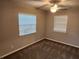 Cozy bedroom featuring two windows, ceiling fan, and neutral carpeting at 11107 Riverview Dr, Riverview, FL 33578