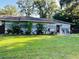 Inviting single-story home with mature landscaping and well-manicured lawn at 11107 Riverview Dr, Riverview, FL 33578