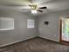 Cozy living room with neutral carpeting, ceiling fan, and bright windows at 11107 Riverview Dr, Riverview, FL 33578