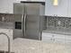 Spacious kitchen featuring stainless steel refrigerator, granite countertops, and a tiled backsplash for a modern look at 11210 Mcmullen Rd, Riverview, FL 33569