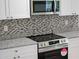 Close-up of a kitchen with stainless steel appliances, granite countertops, and stylish backsplash detailing at 11210 Mcmullen Rd, Riverview, FL 33569