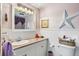 This bathroom includes a white vanity, mirror, and decorative star on the wall at 11296 90Th Ave, Seminole, FL 33772