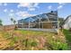 Backyard view of a home with a screened in pool and a wooded area with trees in the background at 11627 Ivy Flower Loop, Riverview, FL 33578