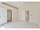 Spacious bedroom showcasing high ceilings, white tile flooring, and multiple doorways at 11627 Ivy Flower Loop, Riverview, FL 33578