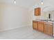 Bright kitchen with white tile flooring, wooden cabinets, and an open layout at 11627 Ivy Flower Loop, Riverview, FL 33578