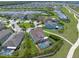 An aerial view of a home with a screened pool surrounded by lush greenery in a residential neighborhood at 11904 Greenchop Pl, Riverview, FL 33579