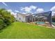Expansive backyard showcasing lush green lawn, landscaping, and screened-in pool area of the house at 11904 Greenchop Pl, Riverview, FL 33579
