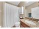 Cozy bathroom with white shower curtain, vanity with granite counter, and modern lighting at 11904 Greenchop Pl, Riverview, FL 33579