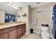 Well-lit bathroom featuring a granite countertop vanity, decorative mirror, and tiled floors at 11904 Greenchop Pl, Riverview, FL 33579