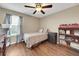 Cozy bedroom with hardwood floors, a ceiling fan, and natural light creates a relaxing space at 11904 Greenchop Pl, Riverview, FL 33579