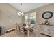 Dining room with natural light, neutral paint, modern chandelier, and views of landscaped backyard at 11904 Greenchop Pl, Riverview, FL 33579