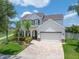 Charming two-story home featuring a brick driveway, lush landscaping, and a welcoming front porch at 11904 Greenchop Pl, Riverview, FL 33579