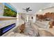 Bright living room with a stone fireplace, large sectional sofa, ceiling fan and views to other rooms at 11904 Greenchop Pl, Riverview, FL 33579