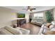 Inviting living room showcases a fireplace, large TV, hardwood floors, ceiling fan, and comfortable seating at 11904 Greenchop Pl, Riverview, FL 33579