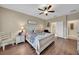 Comfortable main bedroom with wood floors, a ceiling fan, and en-suite bathroom at 11904 Greenchop Pl, Riverview, FL 33579