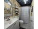Charming bathroom with a vanity, stylish mirror, patterned wallpaper and a shower at 12021 Club House Rd, Brooksville, FL 34613