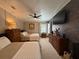 Bedroom featuring two beds, dark wooden furniture, and a large mounted television at 12021 Club House Rd, Brooksville, FL 34613