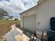 Attached garage with a roll-up door and partial view of the spacious backyard at 12021 Club House Rd, Brooksville, FL 34613