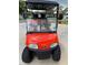 Close-up of an orange E-Z-GO golf cart with custom wheels and a windshield at 12021 Club House Rd, Brooksville, FL 34613