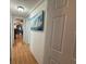 Hallway with wood floors featuring art and an open view into other rooms at 12021 Club House Rd, Brooksville, FL 34613