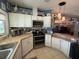 Well-lit kitchen with stainless steel appliances, breakfast bar, and open floor plan at 12021 Club House Rd, Brooksville, FL 34613