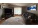 Well-lit living room featuring a plush sofa, decorative rug, and an entertainment center at 12021 Club House Rd, Brooksville, FL 34613