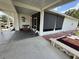 Charming outdoor space with a covered patio, decorative bench, palm tree art, and privacy shades at 12021 Club House Rd, Brooksville, FL 34613