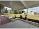 Comfortable covered patio with neutral colors, potted plants, mulched flowerbeds and a cozy seating area at 12021 Club House Rd, Brooksville, FL 34613