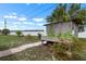 Backyard with white lattice shed covered in vines, brick pavers, and lush plants at 1205 Desert Hills Dr, Sun City Center, FL 33573