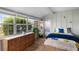 Bright bedroom featuring lots of windows, wood floors, a wooden dresser and queen-size bed at 1205 Desert Hills Dr, Sun City Center, FL 33573
