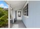 A covered entryway featuring a modern white door and gray concrete at 1205 Desert Hills Dr, Sun City Center, FL 33573