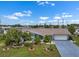 Charming blue home featuring a well-manicured lawn and a long driveway at 1205 Desert Hills Dr, Sun City Center, FL 33573