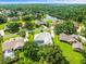 Aerial view showcases a community with tree-lined streets and beautiful homes near a tranquil lake at 13608 Lytton Way, Tampa, FL 33624