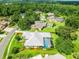 Aerial view of a home with a screened pool, lush landscaping, and a serene neighborhood setting at 13608 Lytton Way, Tampa, FL 33624