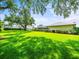 Lush green backyard featuring a screen-enclosed pool, vibrant landscaping, and privacy hedges at 13608 Lytton Way, Tampa, FL 33624