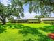 Green backyard featuring a screened-in pool area, lush landscaping, and a peaceful setting at 13608 Lytton Way, Tampa, FL 33624